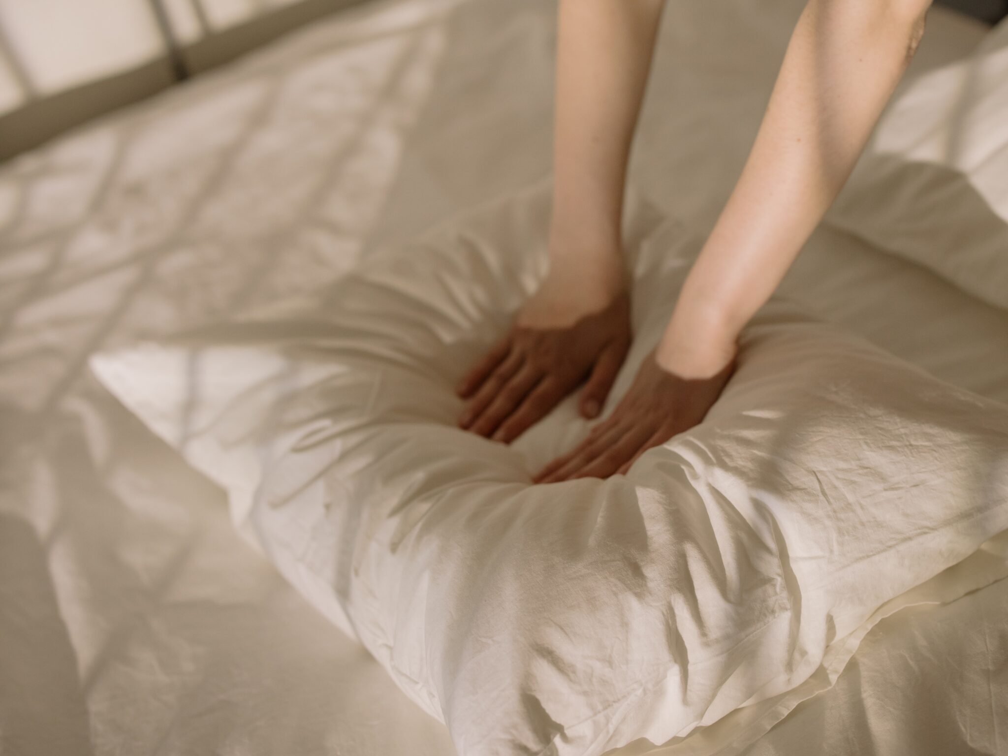 hands pressing on a soft pillow